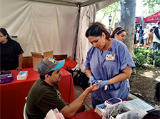 Emmoe Marin, a Keck Hospital of USC medical assistant, checks blood glucose levels of Los Angeles local Alejandro Minera.