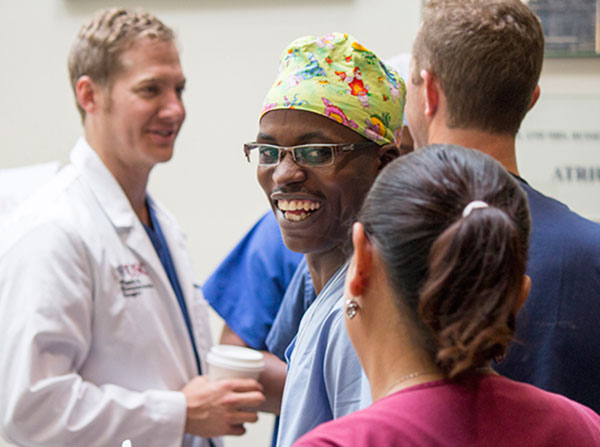 Jean Paul Shumbusho, center, a surgical resident at National University of Rwanda, smiles during a training session May 19. USC faculty and international surgeons exchanged knowledge and honed their skills in a surgical simulation training through Operation Smile, held May 19-21 at the Keck School of Medicine of USC.