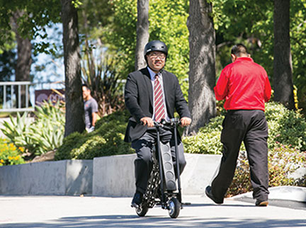 Eric Chang rides an URB-E, a foldable electric scooter, down Eastlake Avenue on the Health Sciences Campus.