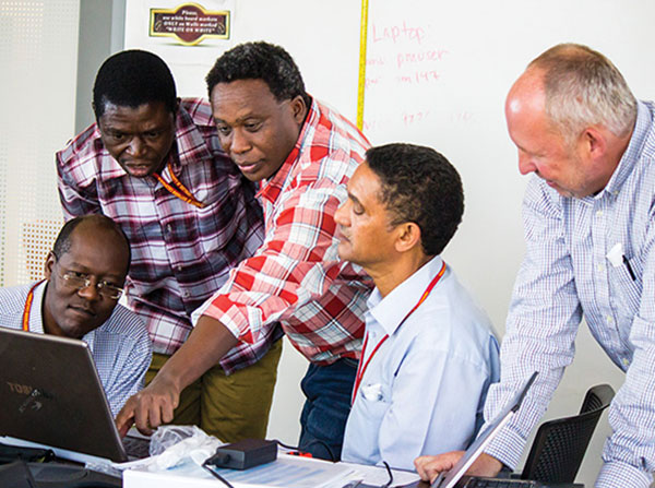 Eastern Africa GEOHealth Hub researchers test each others’ lung function results during a training to use devices called spirometers. From left, Lynn Atuyambe, PhD, Associate Professor at Makerere University College of Health Sciences in Uganda; Augustine Afullo, PhD, MSc, MSc-WEM, MPhil, BSc, Associate Professor at University of Kabianga in Kenya; Etienne Rugigana, PhD, Lecturer and Head of Epidemiology & Biostatistics Department at University of Rwanda School of Public Health; Abera Kumie Takele, MD, PhD, Associate Professor & Head of Environmental and Occupational Sciences at Addis Ababa University School of Public Health in Ethiopia; and Steve Howland, Field Team Project Manager for USC Children’s Health Study.