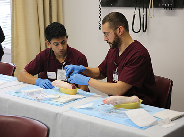 High school student Jose Salazar, left, works with PA student Curtis Ciesinski to learn how to suture in a workshop at a recent USC PA Pipeline event. Outreach like the USC PA Pipeline Program helps recruit students from diverse and disadvantaged backgrounds