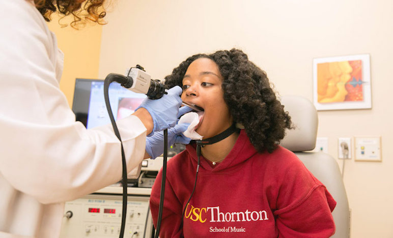 Soprano Vivian Stover, an undergraduate student of the USC Thornton Vocal Arts program, vocalizes while a Keck Medicine of USC laryngologist records a live video feed of Stover’s vocal cords.