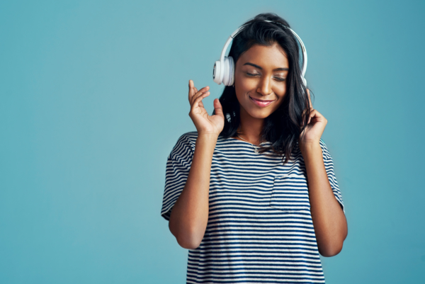 Young woman listening to music on headphones.