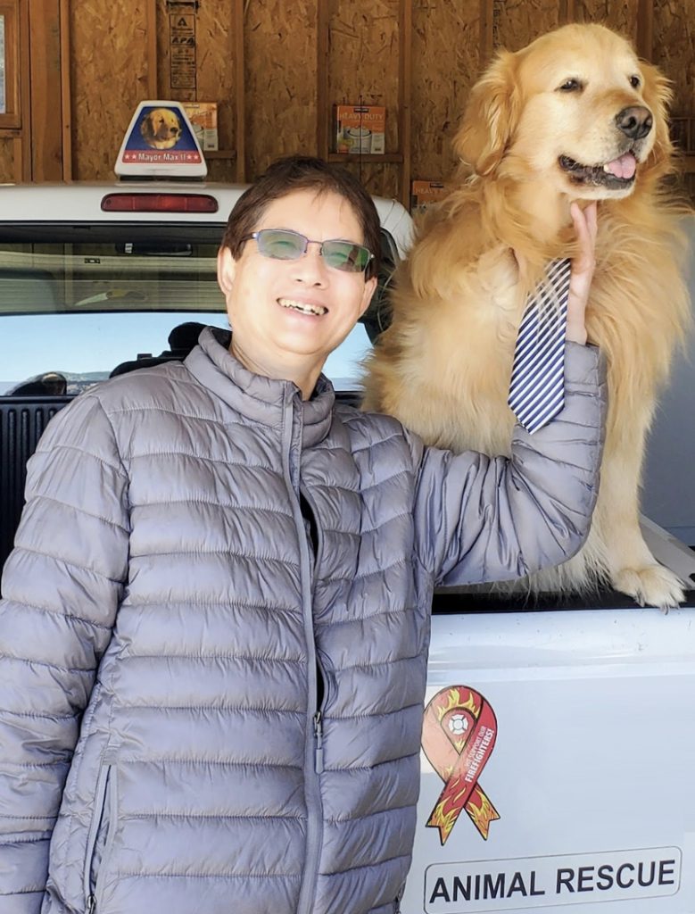 Danny Kwok standing next to his dog and his truck.